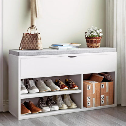 White shoe storage bench with shoes, a handbag, and a plant on top in a room.