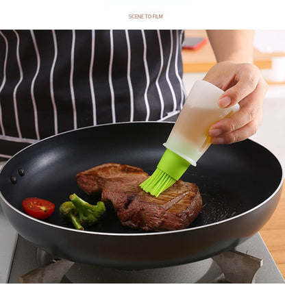 Person cooking steak in a pan with a green brush applying oil, wearing a striped apron.
