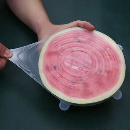 Half of a watermelon with a silicone lid on a dark background