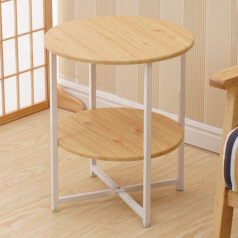 Wooden side table with white metal legs in a room with wooden floor and window.
