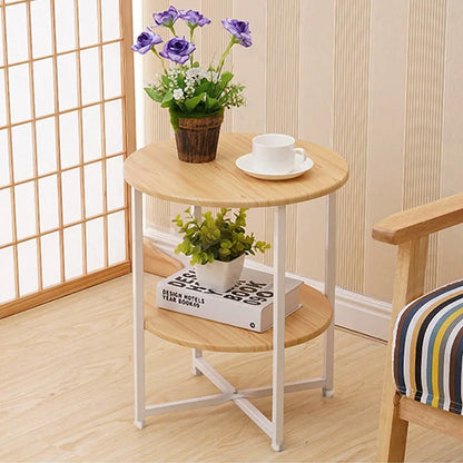 Small round wooden table with a white cup, saucer, and potted plants in a room setting.
