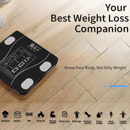 Digital body fat scale on a wooden floor with text about weight loss and health metrics.