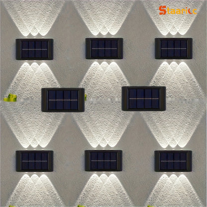 Solar lights mounted on a textured wall with 'Staark' branding.