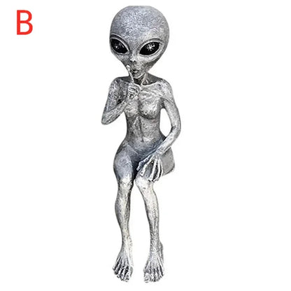 Silver alien figurine on a white background