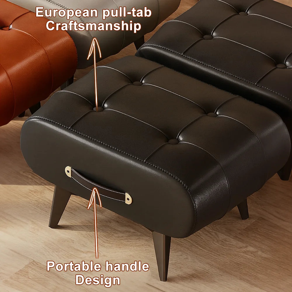 Black leather ottoman with a portable handle design on a wooden floor.