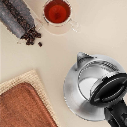Coffee grinder with coffee beans and a cup of coffee on a beige surface