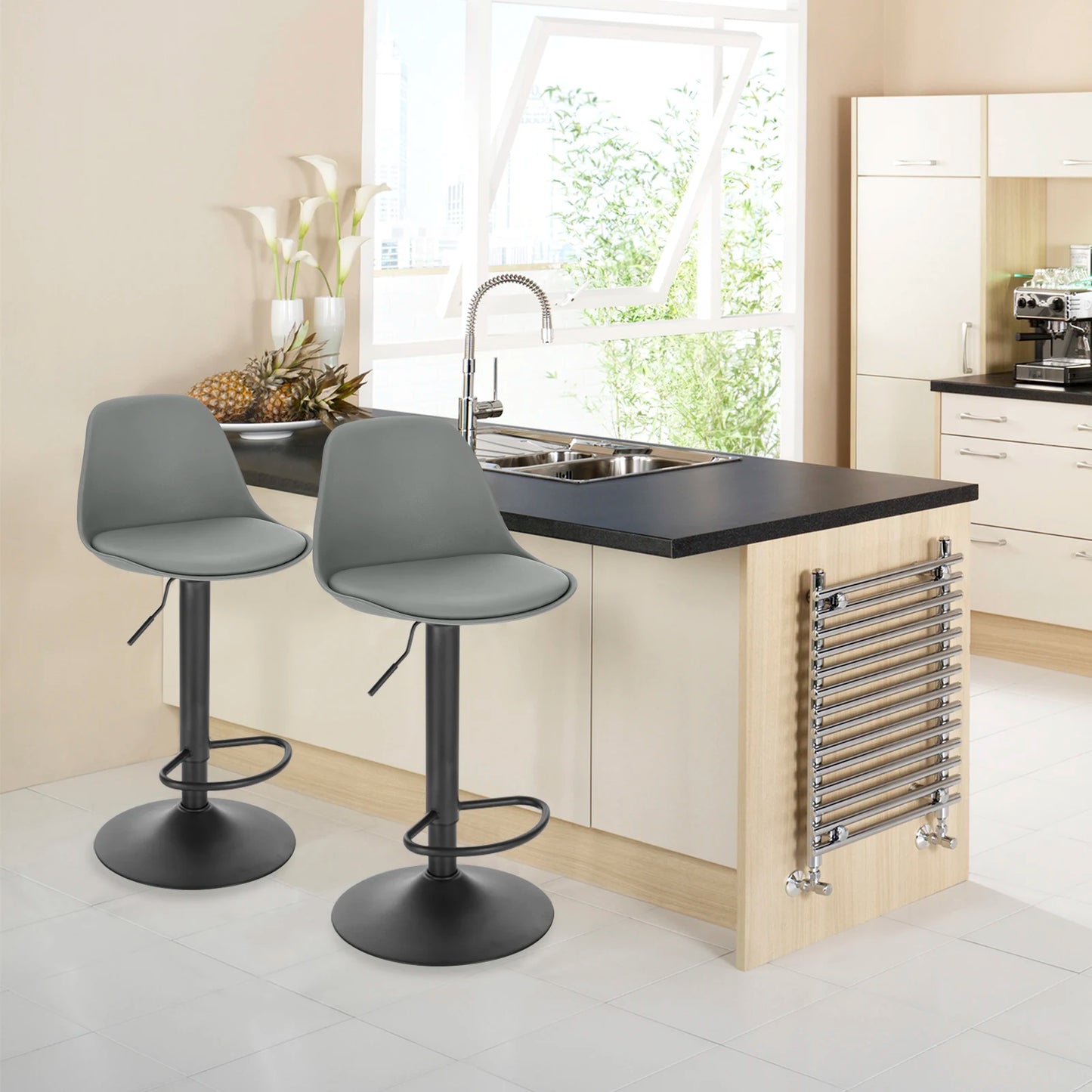 Modern kitchen with gray bar stools, black countertop, and stainless steel faucet.