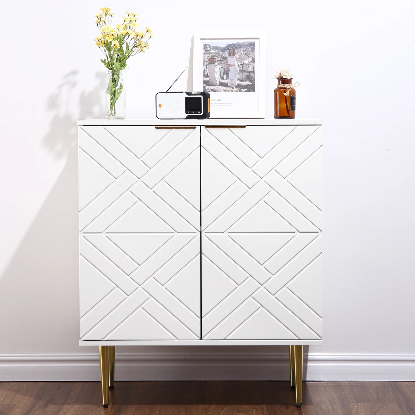 White cabinet with geometric pattern on doors, decorated with a radio, photo frame, and vase.