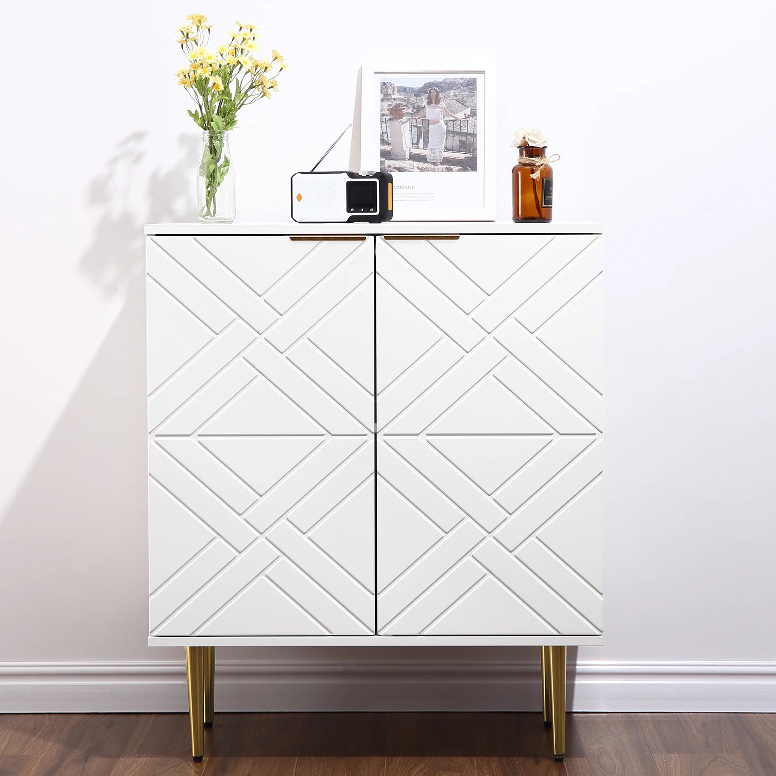 White cabinet with geometric pattern on doors, decorated with a radio, photo frame, and vase.