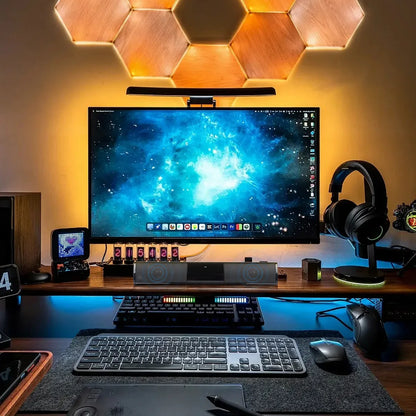 Modern home office setup with a large monitor, keyboard, mouse, and headphones on a desk.
