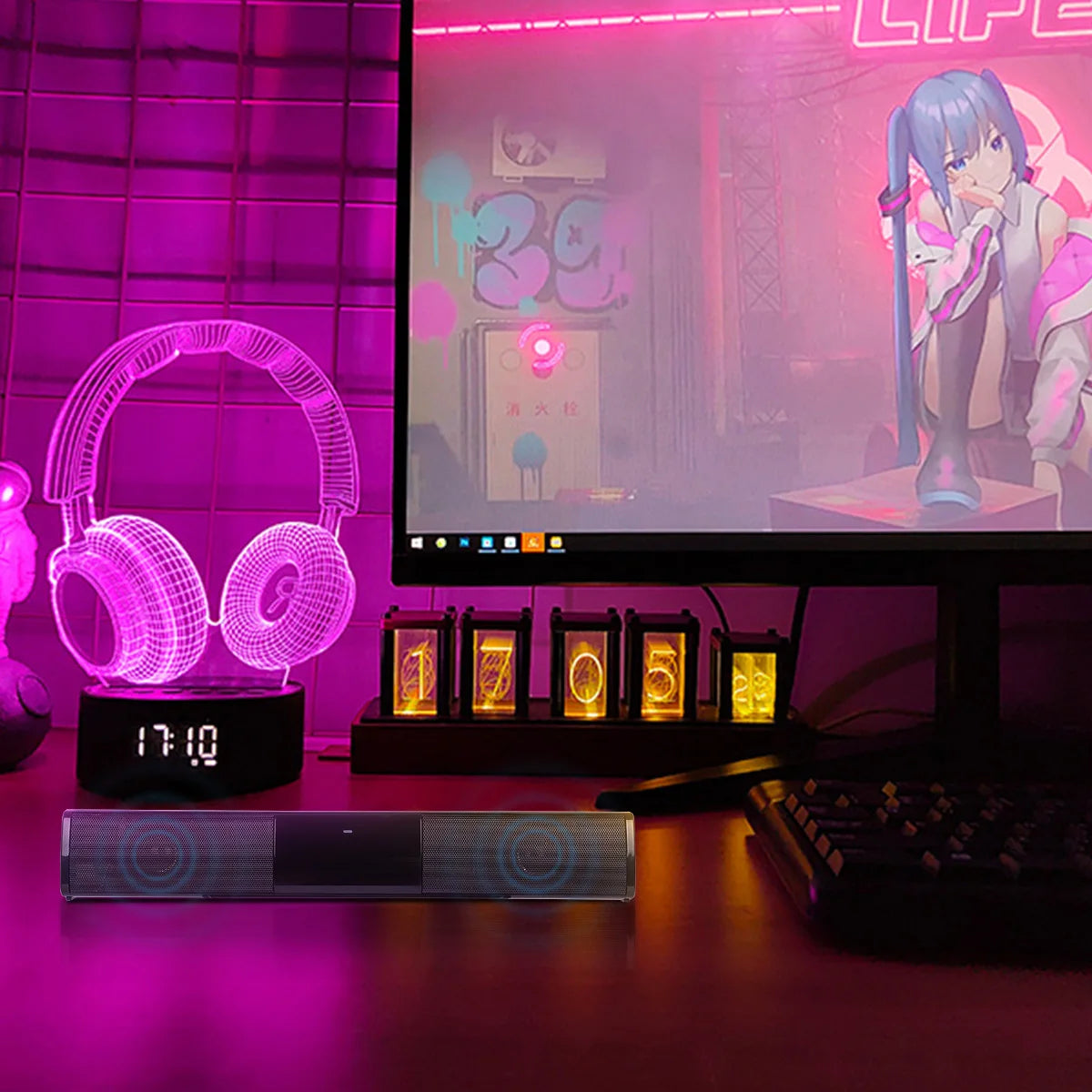 Desk setup with a computer monitor displaying an anime character, 3D headset lamp, and other decorative items on a pink-themed desk.