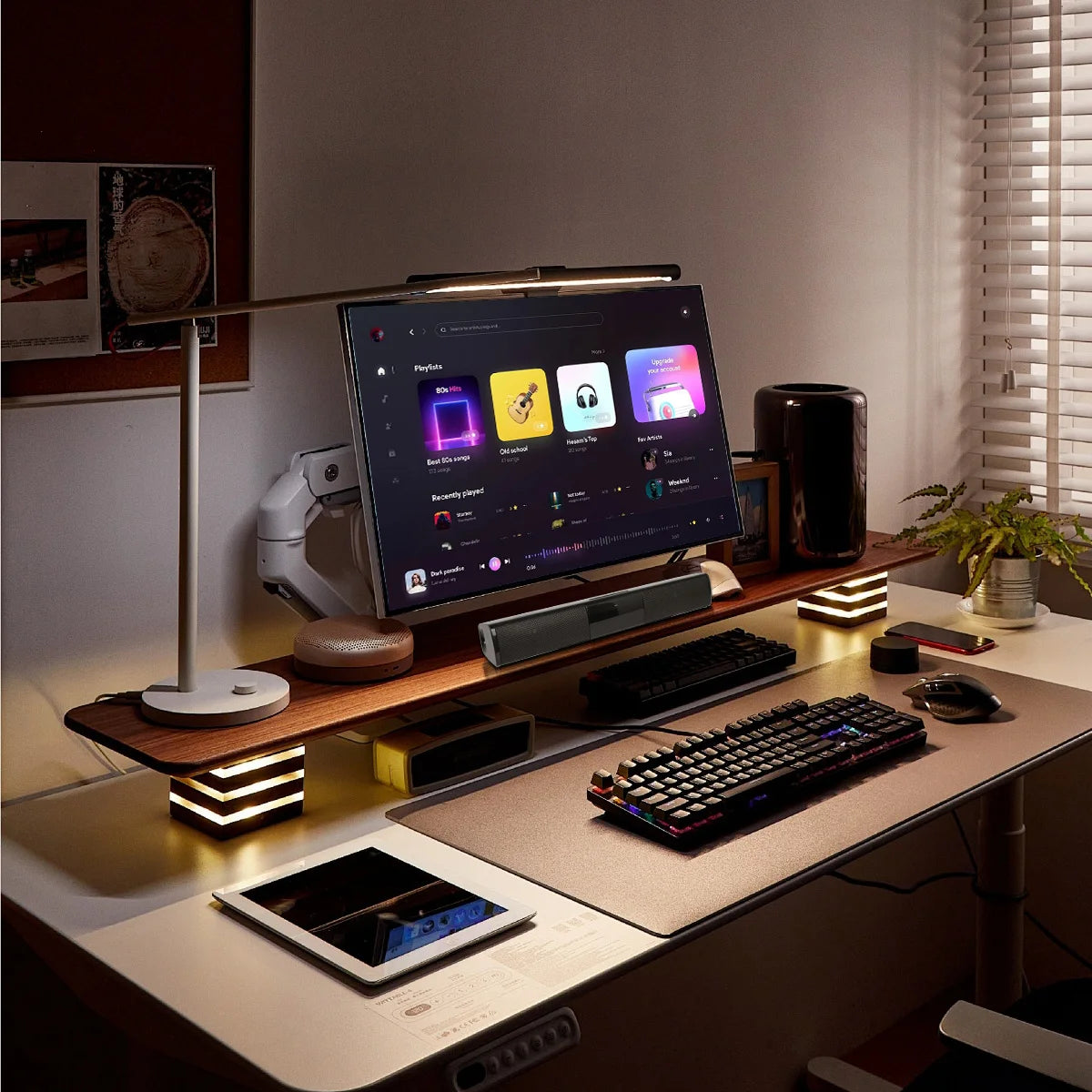 Modern office desk setup with computer monitor, keyboard, and various gadgets.