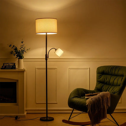 Living room with a green armchair, floor lamp, and fireplace.