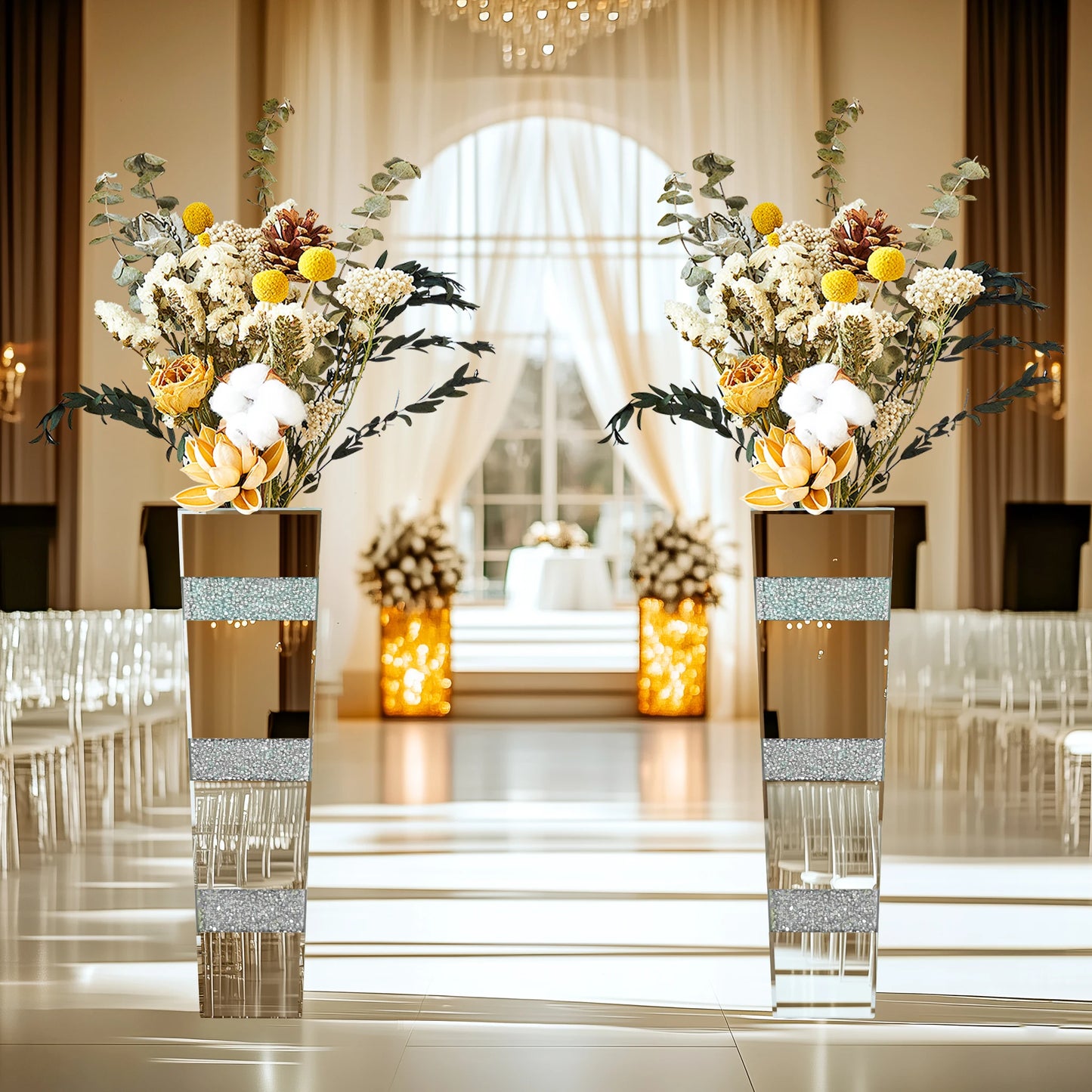Decorative floral arrangements in tall vases with glittery bands on a formal event setting.