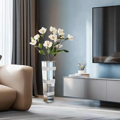 Modern living room with a vase of white flowers, a TV, and a beige armchair.