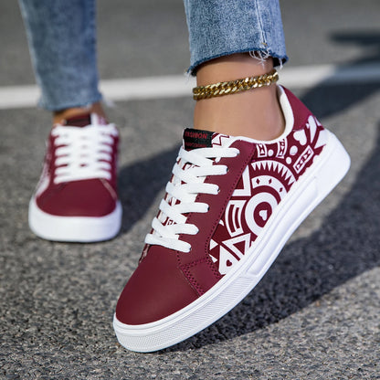 Maroon sneakers with white patterns worn on a street.