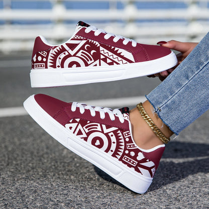 Maroon sneakers with white tribal patterns worn by a person on a blurred street background