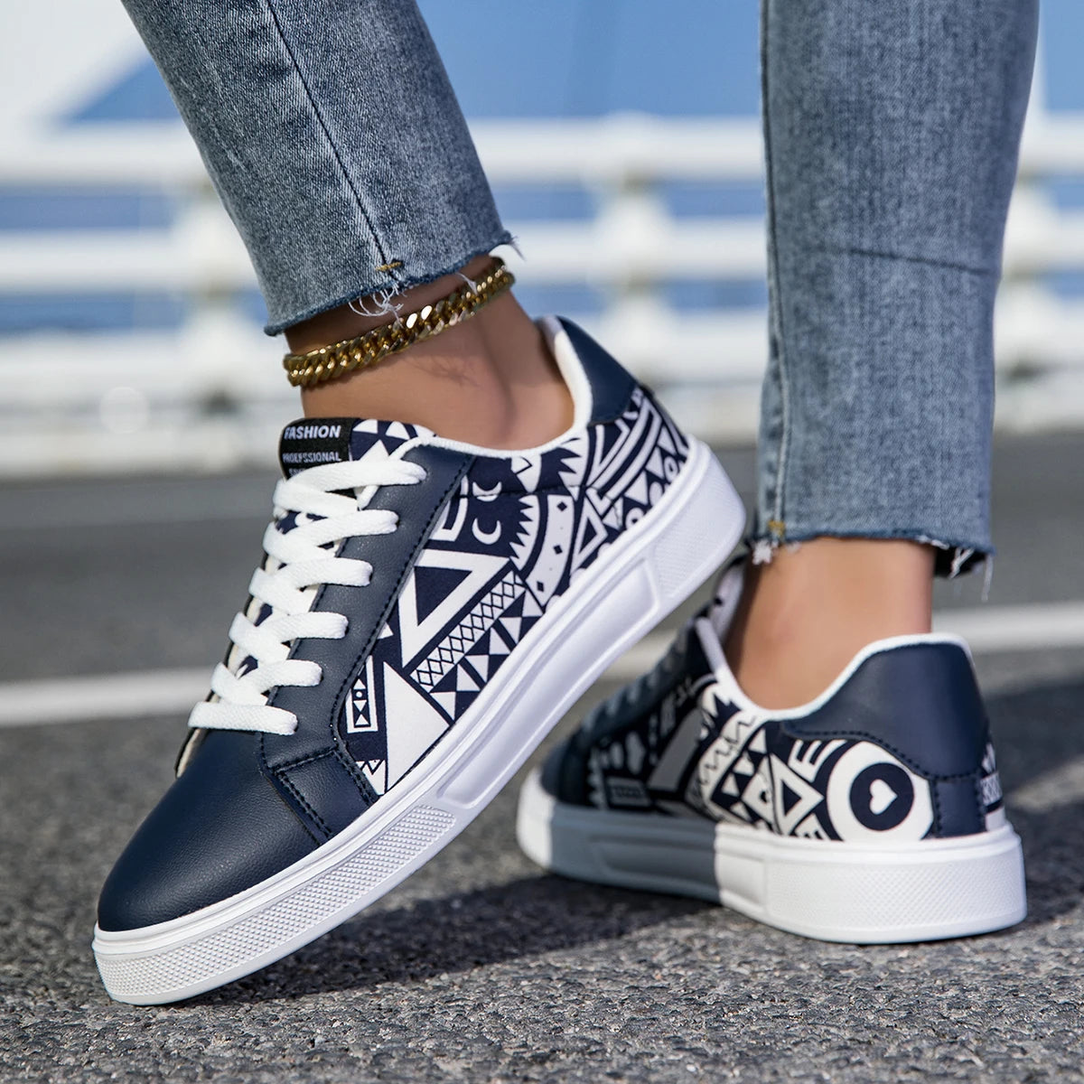 Navy blue sneakers with white patterns worn by a person on a blurred street background
