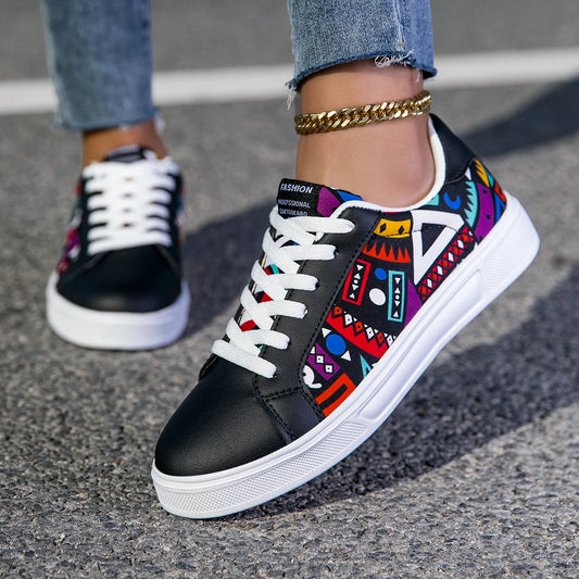 Black sneakers with colorful tribal pattern worn on a street.