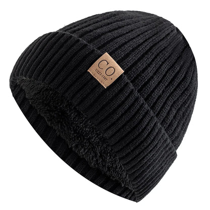 Black ribbed beanie with a brown label on a white background