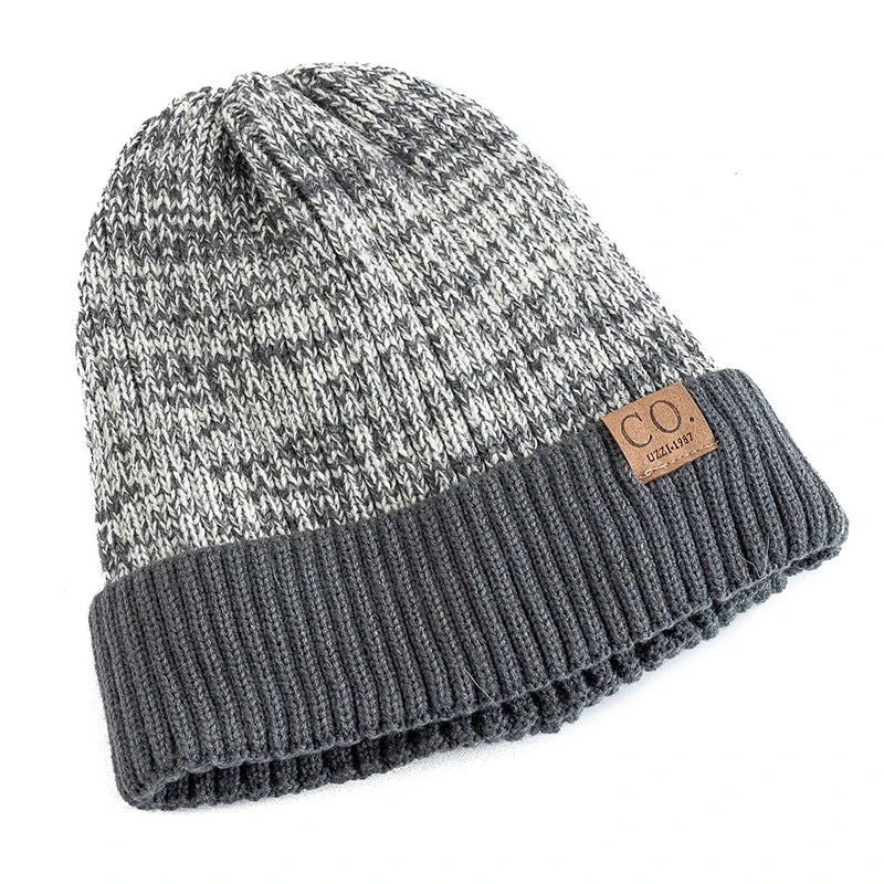 Gray and black marbled knit beanie with a brown leather patch on a white background