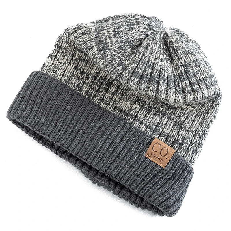 Knitted beanie with a gray and white pattern and a brown leather patch on a white background