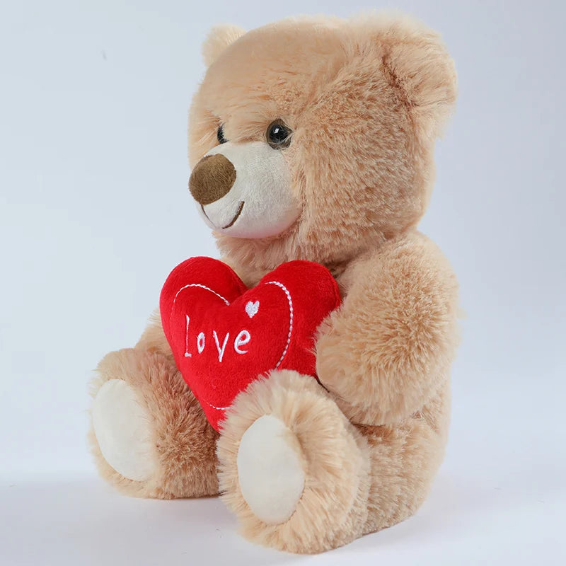 Plush teddy bear holding a red heart with 'love' written on it against a white background
