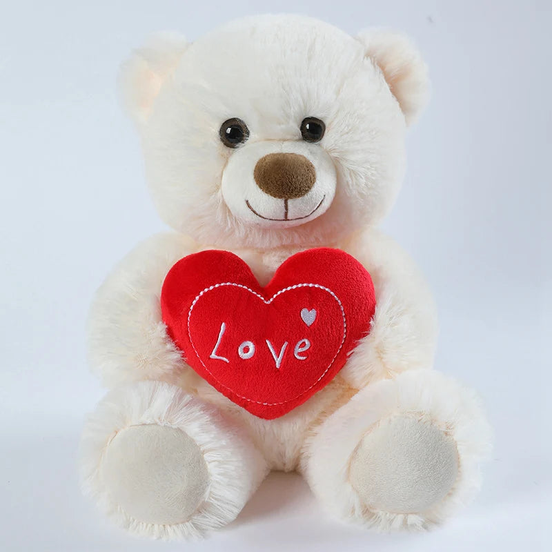 White teddy bear with a red heart that says 'Love' on a white background