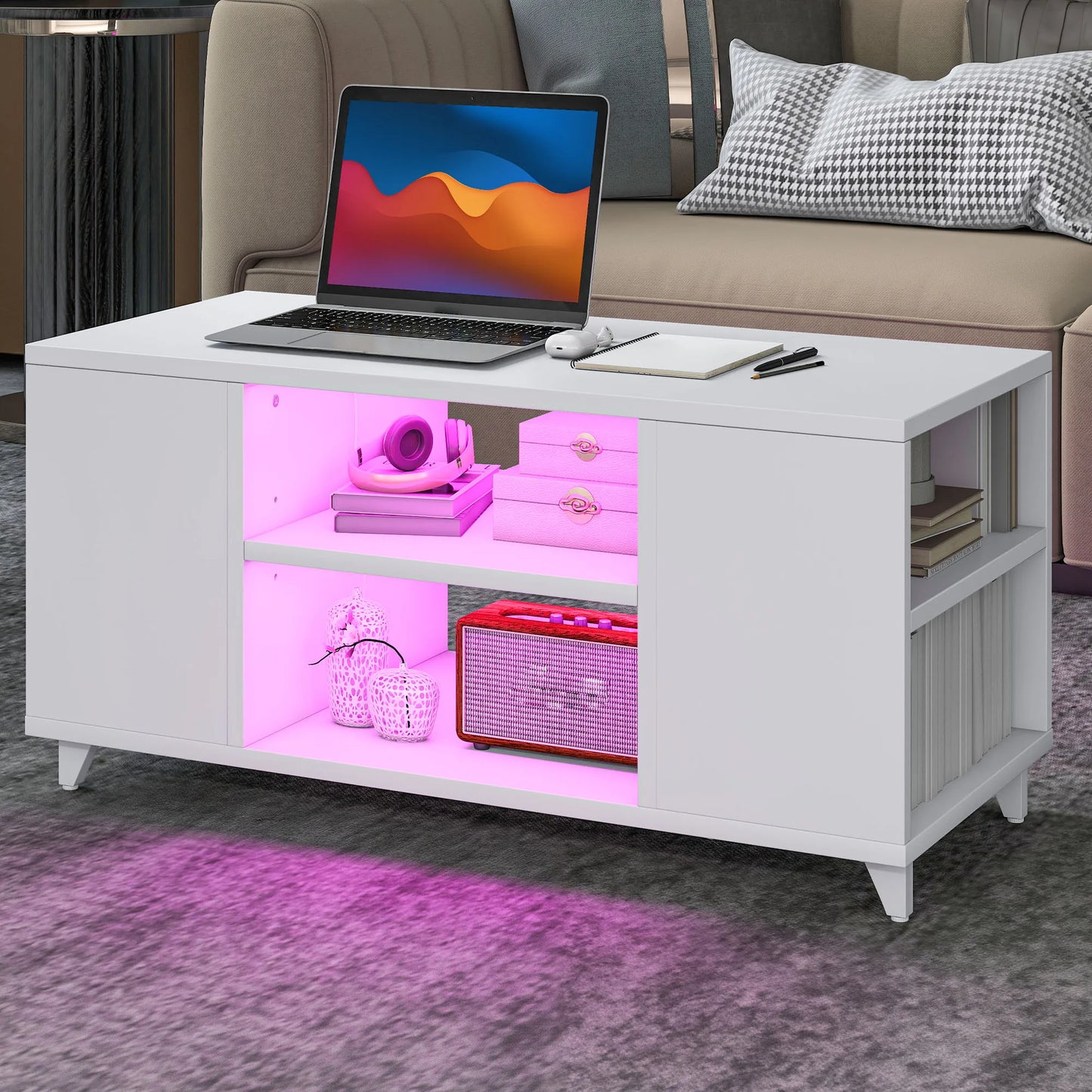 White coffee table with pink LED lighting displaying a laptop and decorative items in a living room setting.