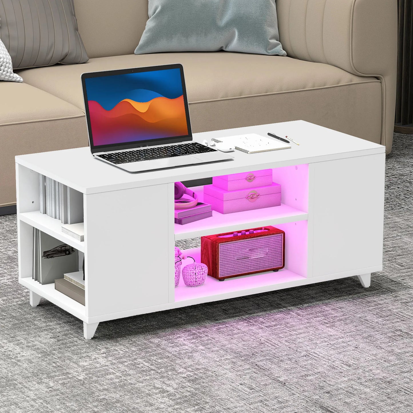 White coffee table with pink LED lighting displaying a laptop and decorative items in a living room setting.