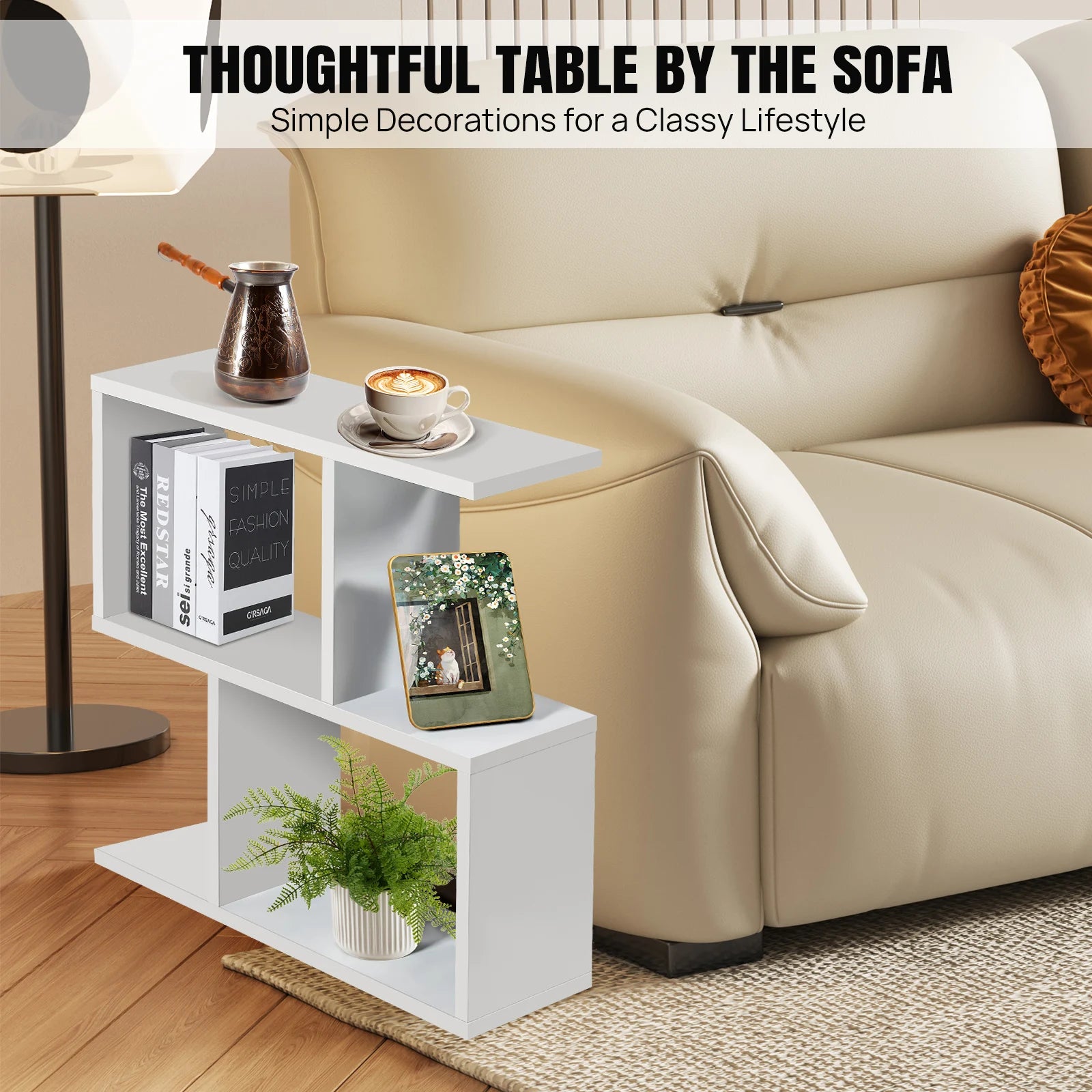 White side table with books, a plant, and a cup next to a beige sofa.