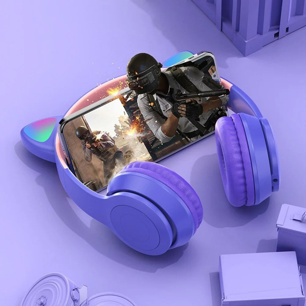Purple headphones with a screen displaying a video game on a purple surface.