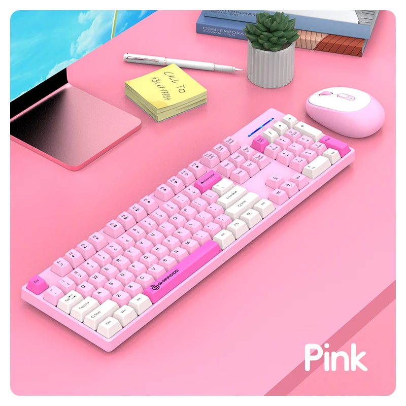 Pink keyboard on a desk with a tablet, mouse, and stationery items.
