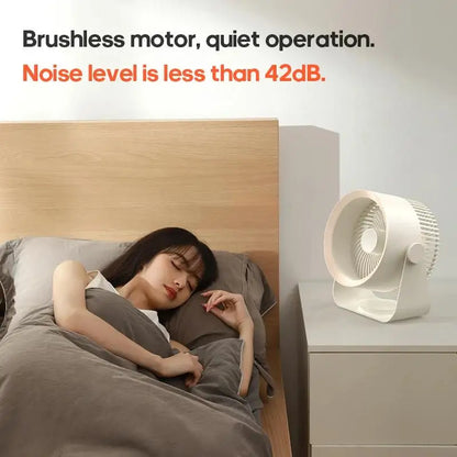 Woman sleeping in bed with a small fan on a nightstand, emphasizing quiet operation.