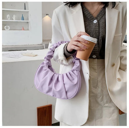 Person holding a purple handbag and a coffee cup in a kitchen setting