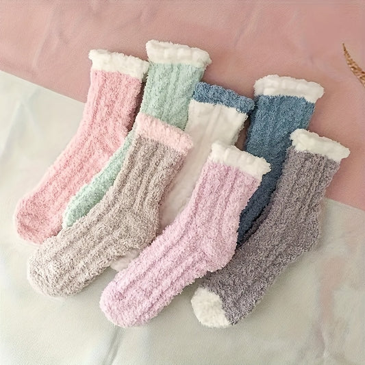 Set of colorful fluffy socks on a light pink background