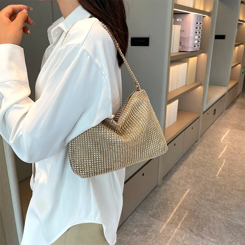 Person wearing a white shirt holding a gold handbag in an indoor setting