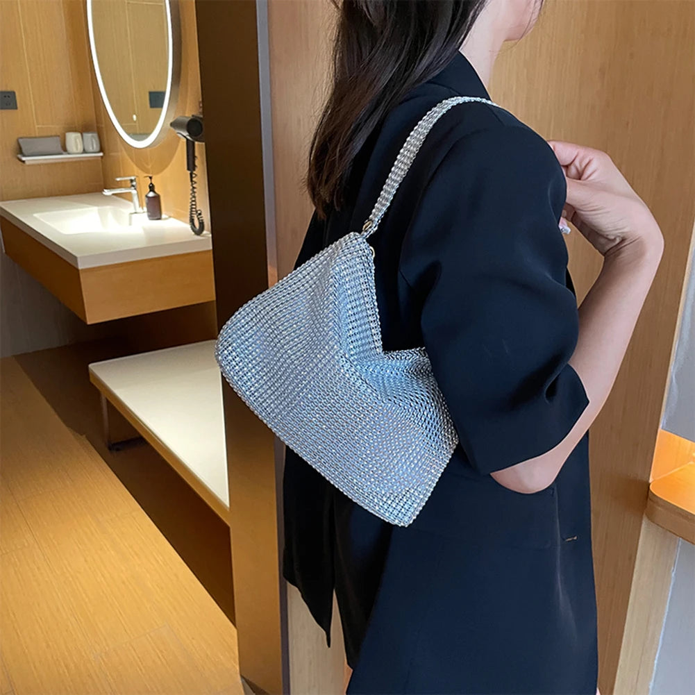 Person holding a blue beaded handbag in a bathroom setting