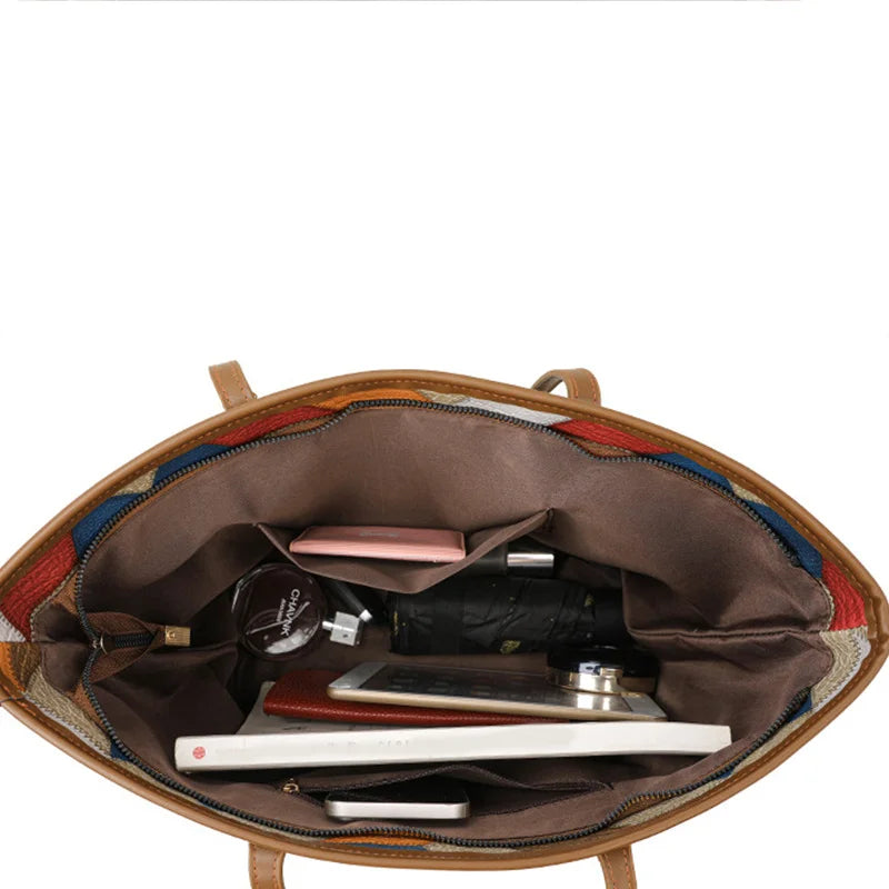 Open brown leather bag with various items on a white background