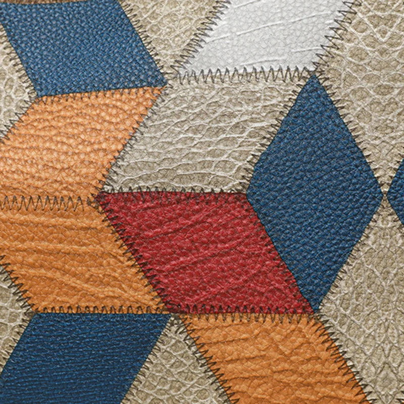 Close-up of a patchwork quilt with diamond-shaped fabric pieces in various colors.